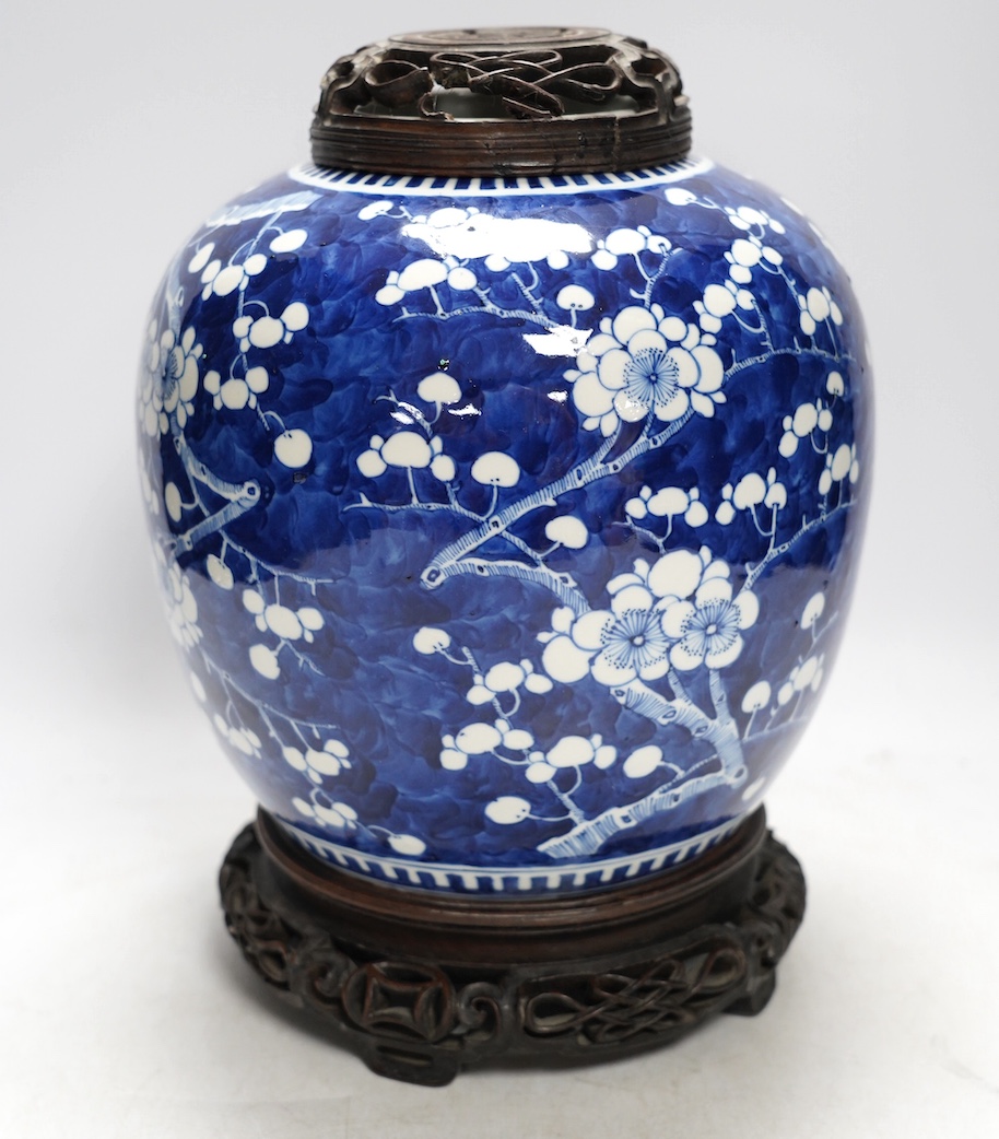 A 19th century Chinese blue and white ginger jar with hardwood stand and cover, overall 30cm high. Condition - jar and stand good, cover repaired